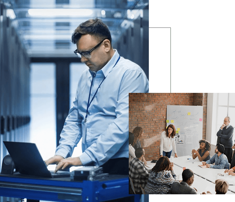 A man is using his laptop while sitting in front of a group.